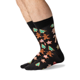 A pair of black crew socks with a festive Christmas gingerbread pattern, worn on a person's feet against a clean white background. thumbnail
