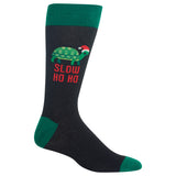 A single dark charcoal gray crew sock with green cuffs, heel, and toe, featuring a green turtle wearing a red Santa hat and the red text 'SLOW HO HO' on the side.