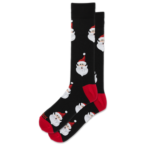 A pair of black crew socks featuring a repeating pattern of Santa Claus faces, with red heels, soles, and toes.