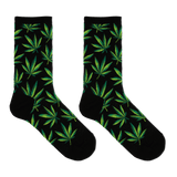 A pair of black crew socks with an all-over green leaf pattern, displayed against a solid white background.