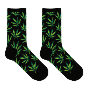 A pair of black crew socks with an all-over green leaf pattern, displayed against a solid white background.