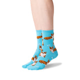 A pair of light blue crew socks with a repeating pattern of brown and white cat illustrations, shown on a person's feet against a white background. thumbnail