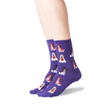 A pair of purple crew socks with a repeating pattern of cartoon dogs dressed as ghosts and witches, shown on a person's feet against a white background. thumbnail