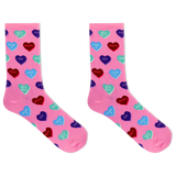 A pair of pink crew socks with an all-over pattern of colorful heart candies in red, blue, purple, and green, each printed with Valentine's themed phrases like 'Kiss Kiss', 'Love You', and 'HUGS'. thumbnail