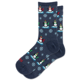 A pair of navy blue crew socks with a repeating pattern of penguins on ice, snowflakes, and small red accents.