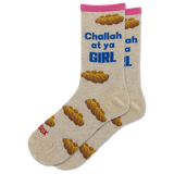 A pair of beige crew socks with a pink cuff, featuring a pattern of braided bread loops and blue text that reads 'Challah at ya GIRL'. One sock also has red text reading 'Sax' near the toe.