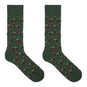 A pair of dark green crew socks with an all-over golf course pattern featuring red and white golf carts, golf balls, flags, and a golfer, displayed against a solid white background.