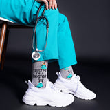 Person wearing teal scrubs with a stethoscope, white sneakers, and socks with 'Trust me, I'm a doctor' text and dog illustrations.
