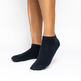 A pair of low-cut black socks worn on a person's feet, shown against a plain white studio background. thumbnail