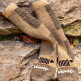 Pair of brown and beige socks with Jeep logo on a stone surface