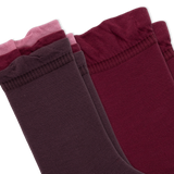 Two pairs of crew socks fanned out on a white background, with three tiers of ruffled colors from dark plum to burgundy, maroon, and dusty pink.