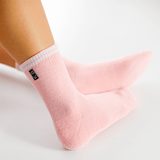 Pink socks with a brand logo on a light gray background