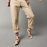 Person wearing beige pants and patterned socks with cars and surf boards on a gray background thumbnail
