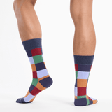 Colorful checkered socks worn by a person on a white background thumbnail