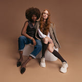 Two women sitting on a white stool against and k.bell socks on a brown background thumbnail