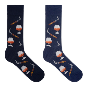 A pair of men's navy blue crew socks with a cognac and cigars theme, featuring illustrations of a cognac glass, a cigar, and other smoking accessories.